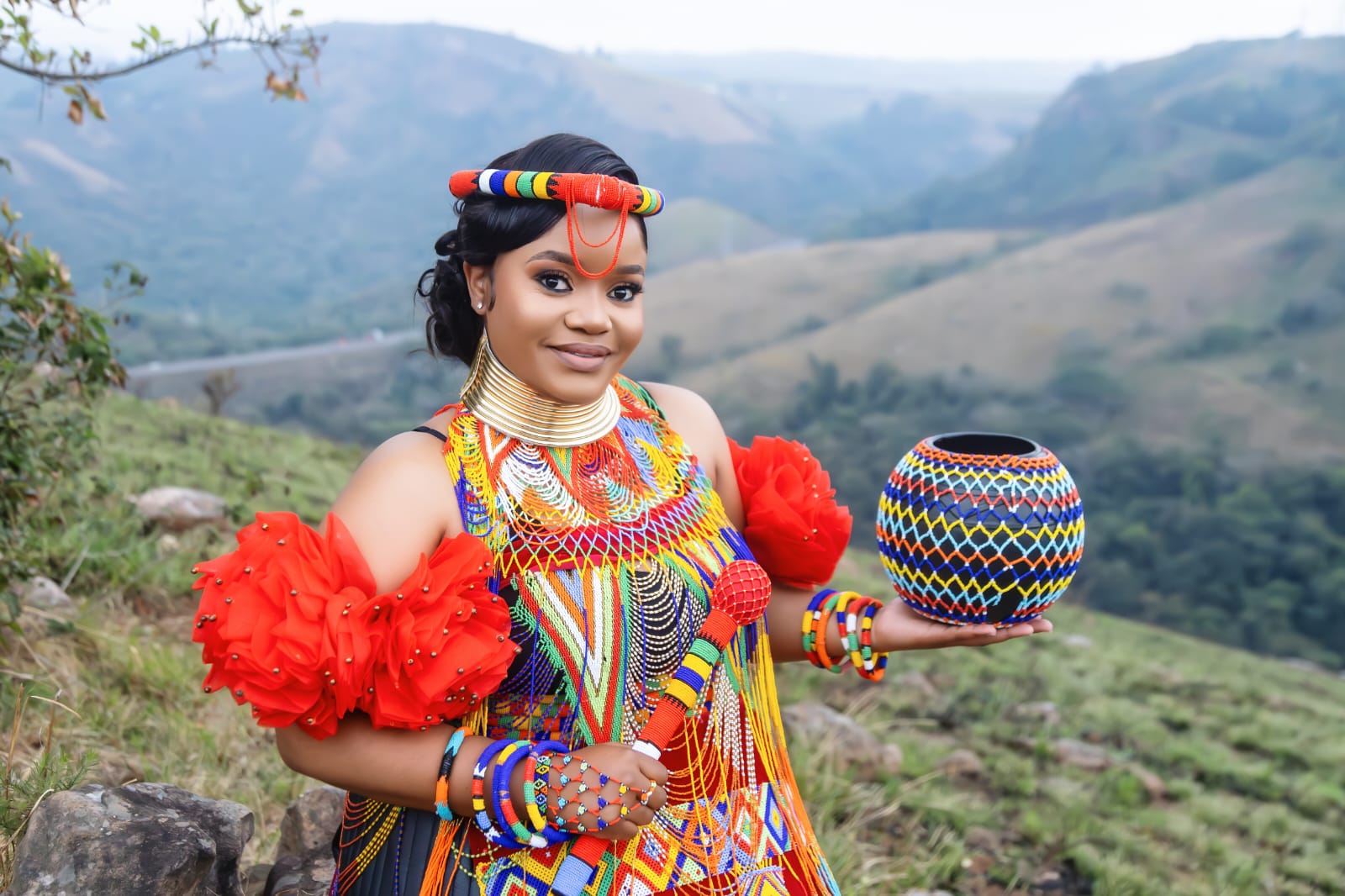 The groom in traditional attire against the hills